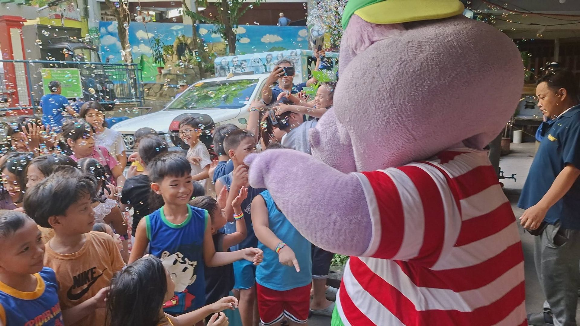 Children gathered around a costumed mascot