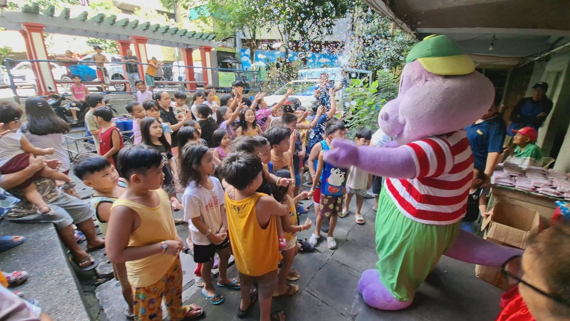 A costumed mascot greeting a crowd of children